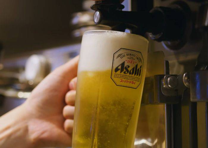 A freshly poured pint of Asahi beer in a frosty glass.